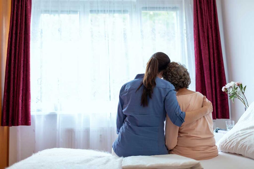 Older adult and family member reviewing care questions with a staff member in a bright assisted living common room.